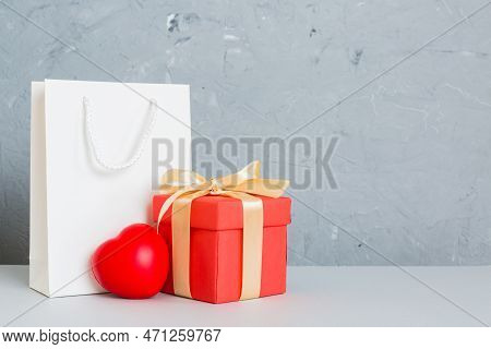Shopping Bag With Gift Box On Colored Background Perspecrive View. Space For Text Holiday Concept.