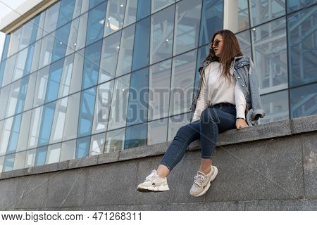 Attractive Stylish Woman Resting On City Street.young Woman In Sunglesses In Youth Clothing On The C