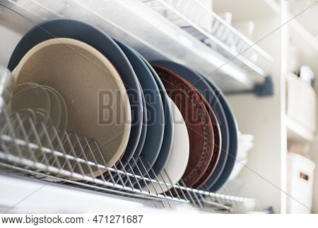 Ceramic And Glass Plates Of Different Sizes In The Kitchen Cabinet. Horizontal
