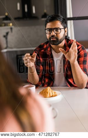 Young Diverse Loving Couple Eating Croissant And Talks Together At Home In Breakfast Time. Communica