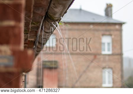 A Gutter On A Building, An Old Drainpipe Close-up, Water Flows Through Rotten Metal, There Is A Plac