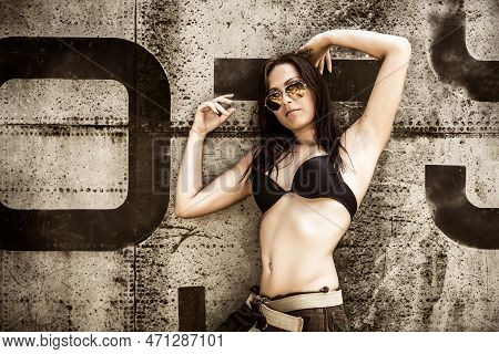 Portrait Of A Young Girl With Mimetic Military Dress Near The Old Abandoned Broken Plane. Concept Mi