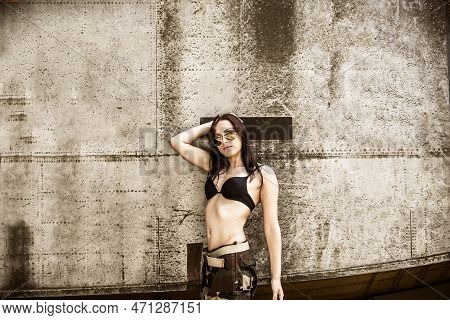 Portrait Of A Young Girl With Mimetic Military Dress Near The Old Abandoned Broken Plane. Concept Mi