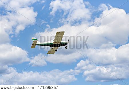 Single Engine Ultralight Plane Flying In The Blue Sky With White Clouds