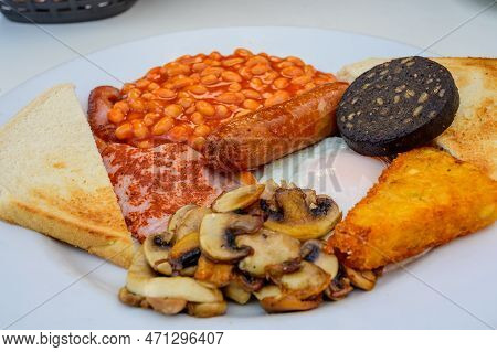 White Board With Full English Breakfast With Bacon, Fried Egg, Beans, Tomato, Roasted Sausage, Black