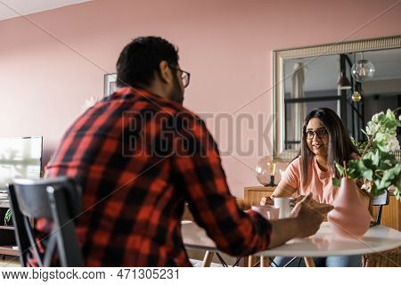 Young Diverse Loving Couple Eating Croissant And Talks Together At Home In Breakfast Time. Communica