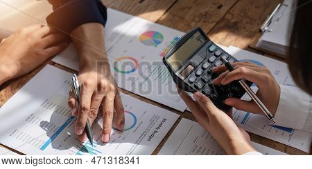 Female And Male Accountant Use Calculator To Calculate The Company Financial Results With On Data Ne