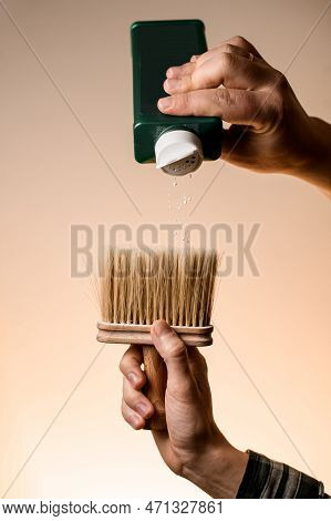 Male Hand Holds Talcum Brush And Gently Pours Talcum Powder From A Bottle