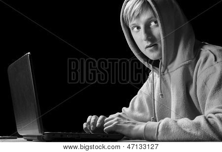hacker. Giovane uomo con il computer portatile è guardando indietro