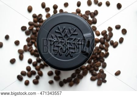 Plastic Cover About A Snowflake On A Coffee Cup. Winter Cup Among Coffee Beans. A Plastic Cup Among