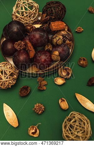 Uicy Plums On A Gold-rimmed Platter. On A Green Background.
