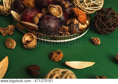 Uicy Plums On A Gold-rimmed Platter. On A Green Background.