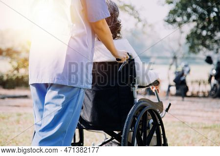 Asian Young Caregiver Nurse Support Senior Older Male Walking Outdoors. Specialist Girl Doctor Help