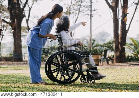 Asian Young Caregiver Nurse Support Senior Older Male Walking Outdoors. Specialist Girl Doctor Help