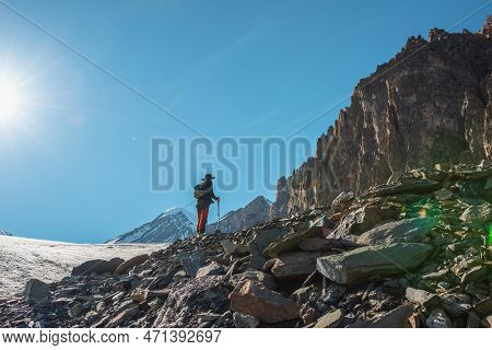 Scenic Alpine Landscape With Silhouette Of Hiker With Trekking Poles Against Large Sharp Rocks And S