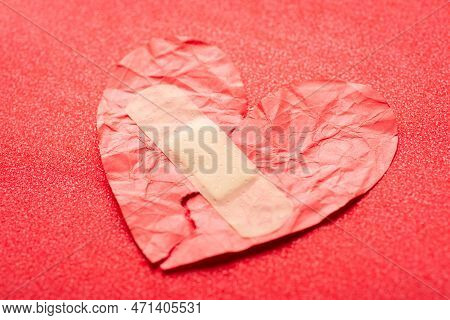Torn And Fixed With Plaster Broken Heart. Heart With Adhesive Plaster On Red Background, Concept Of 