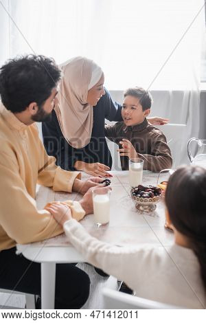 Muslim Family Talking During Traditional Suhur Breakfast At Home.
