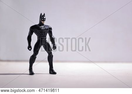 Kopeysk, Russia - August 11, 2021. Batman Toy Stands Sideways On Gray Background Background