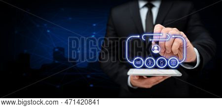 Businessman In Office Suit Holding Tablet And Pen. Written Virtual Text On Screen. Futuristic Image 