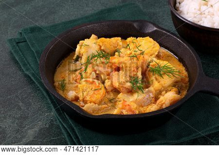 Fish Curry With Codfish, Pollack And Shrimps With Coconut Milk Served In Cast Iron Pan