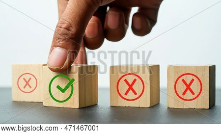 Male Hand Putting A Green Tick On A Wooden Cube. Changing Mindset Is Right Or Wrong. Quiz Answers An