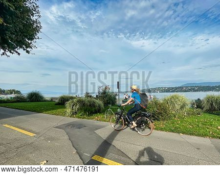 Geneva, Switzerland - September 14 2021: A Person With Helmet On On A Bike Is Cycling Along The Lake