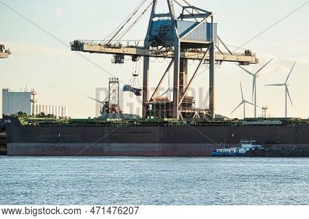 Rotterdam, Netherlands - November 22 2021 : Iron Ore Is Being Unloaded By Huge Cranes In Het Industr
