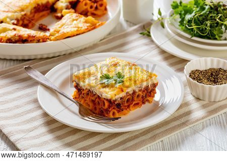 Greek Pastitsio Of Pasta, Ground Lamb, Grated Cheese, And Tomatoes Topped With Bechamel Sauce And Me
