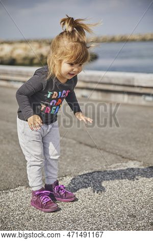 Stylish Child Playing On The Embankment In Denmark