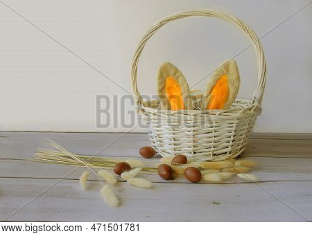 Easter Eggs And A White Basket With Rabbit Ears
