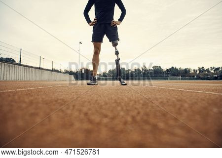 A Tired Sportsman With Artificial Leg Taking A Break Form Exercising On Running Track At Stadium.