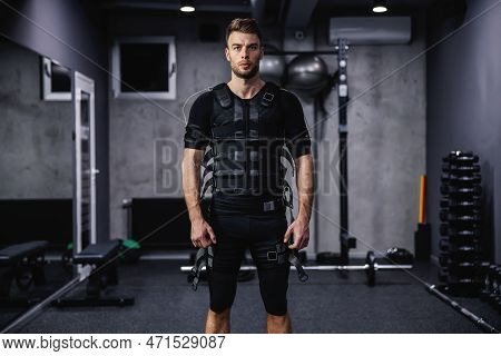 Electrical Muscle Stimulation. A Confident Hot Male Person Dressed In A Special Suit For Ems Technol