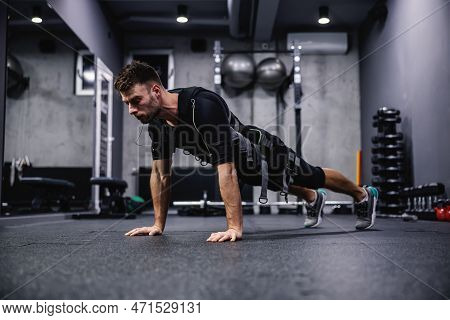 Modern Training Concept On Electrical Muscle Stimulation. Side View Of A Male Wearing An Ems Suit An