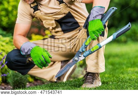 Caucasian Professional Garden And Landscape Worker With Large Manual Hedge Trimmers In His Hands