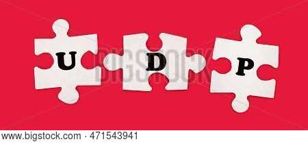 Three White Jigsaw Puzzles With The Text Udp User Datagram Protocol On A Bright Red Background.