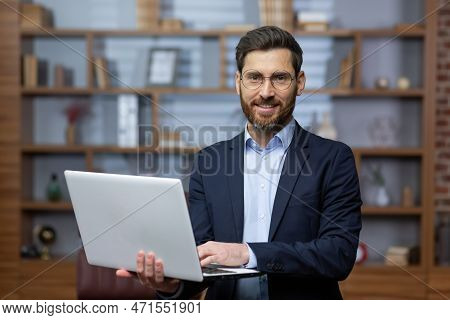 Portrait Of Mature Businessman Inside Office, Senior Man In Business Suit And Beard Standing And Hol