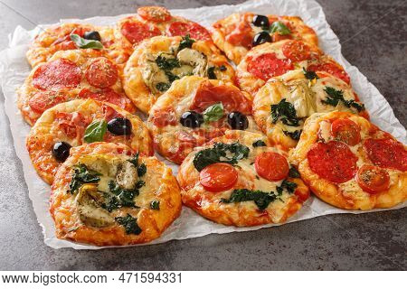 Italian Pizzette Mini Pizza Bites With Assorted Toppings Close-up On Parchment On The Table. Horizon