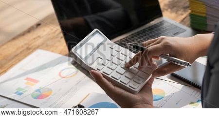 Business Woman Using Calculator To Calculate Financial Report, Working At Office With Laptop Compute