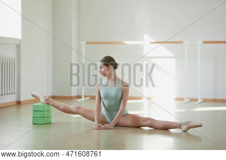 Tender Teen Girl, Ballerina Training In Ballet School On Daytime. Stretching Exercises, Sitting On T