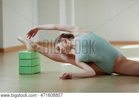 Beautiful Teen Girl, Professional Female Ballerina Training In Ballet School On Daytime. Sitting On 