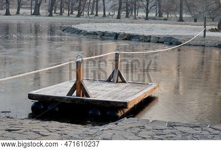 Wooden Raft Is Tied To A Taut Rope. Self-service Ferry Across The River, Pond. People Get On And Pul
