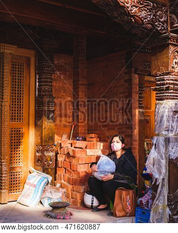 Kathmandu, Nepal, 04 23 2022: A Girl Taking A Break In Kathmandu Bazaar During The Pandemic, Wearing