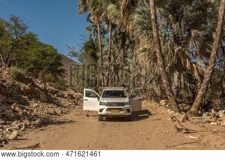 Car On A Dusty Gravel Road Along The Kunene River In Northern Namibia