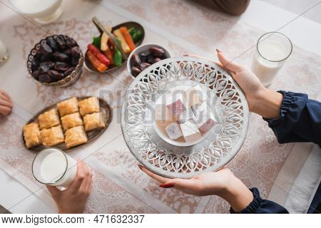 Top View Of Muslim Woman Holding Turkish Delight Near Child During Suhur In Morning.
