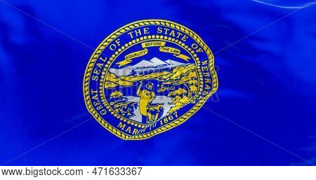 Close-up Of The Nebraska State Flag Fluttering. The Flag Of Is Blue With The State Seal In The Cente