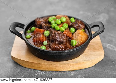 Delicious Beef Stew With Carrots, Peas And Potatoes On Grey Table, Closeup