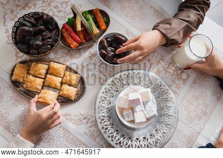 Top View Of Muslim Kids Taking Food Near Mother During Suhur Breakfast At Home.