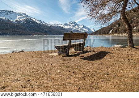 Silvaplana, Switzerland, February 21, 2023 Place To Rest With A Cozy Bench At The Coast Of The Lake 