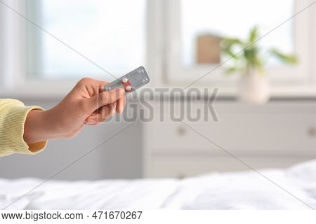 Woman Holding Blister Of Emergency Contraception Pills In Bedroom, Closeup. Space For Text