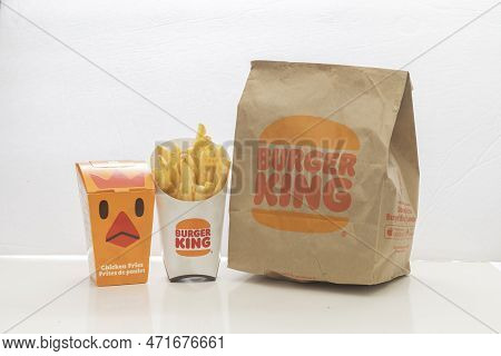 Calgary, Alberta, Canada. Feb 27, 2023. A Burger King Bag And A Package Of French Fries With A Box W